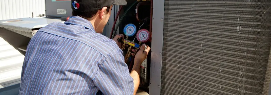 HVAC technician servicing a condenser unit in Chestnuthill